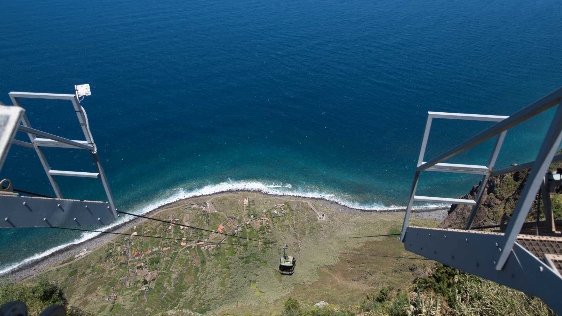 Cable car descends slope toward the sea.