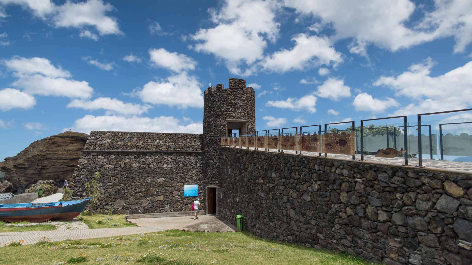 Fortaleza de pedra com ponte e pessoas a entrar.