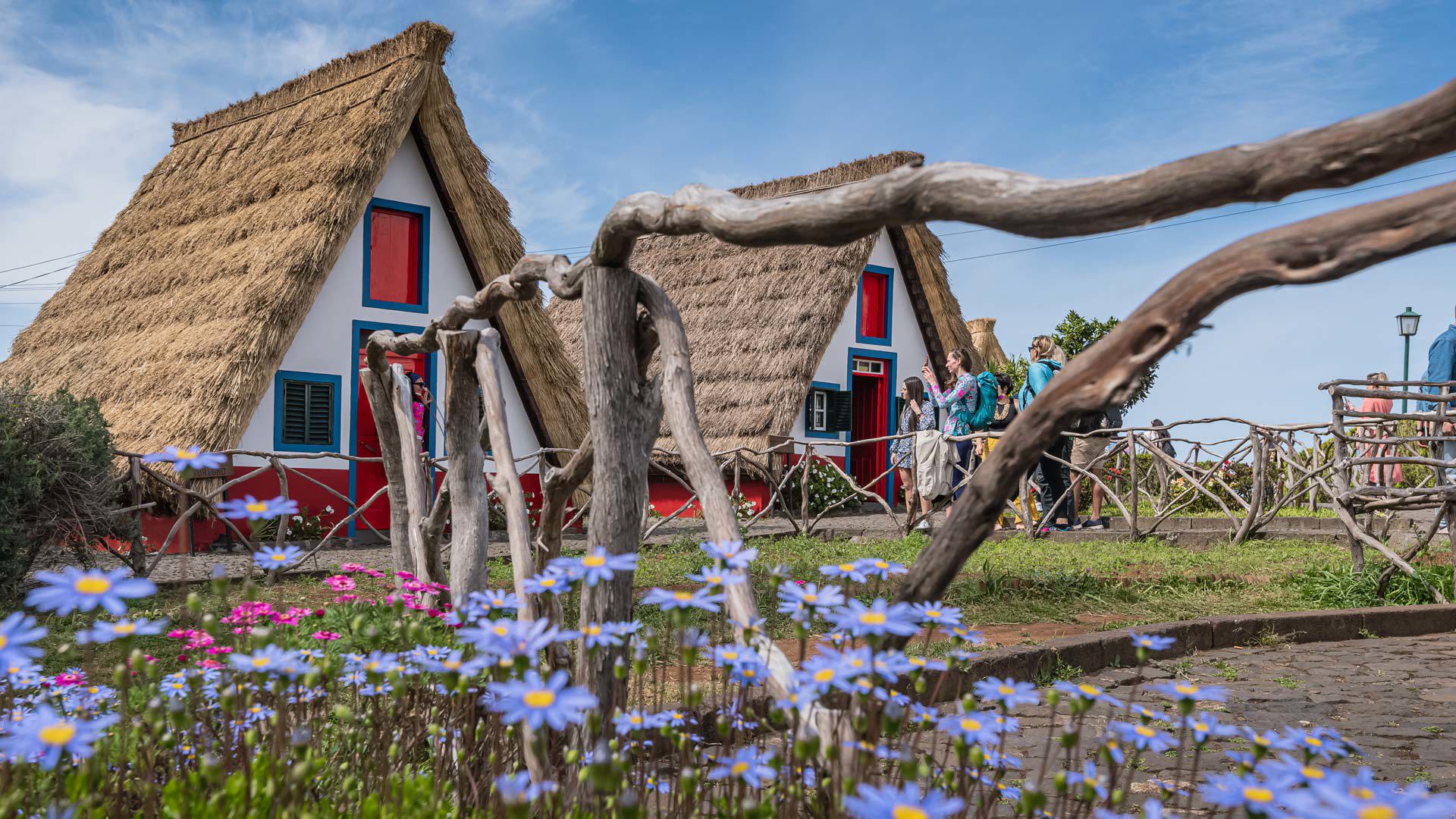 Maisons traditionnelles avec personnes proches et clôture en bois à Madère.