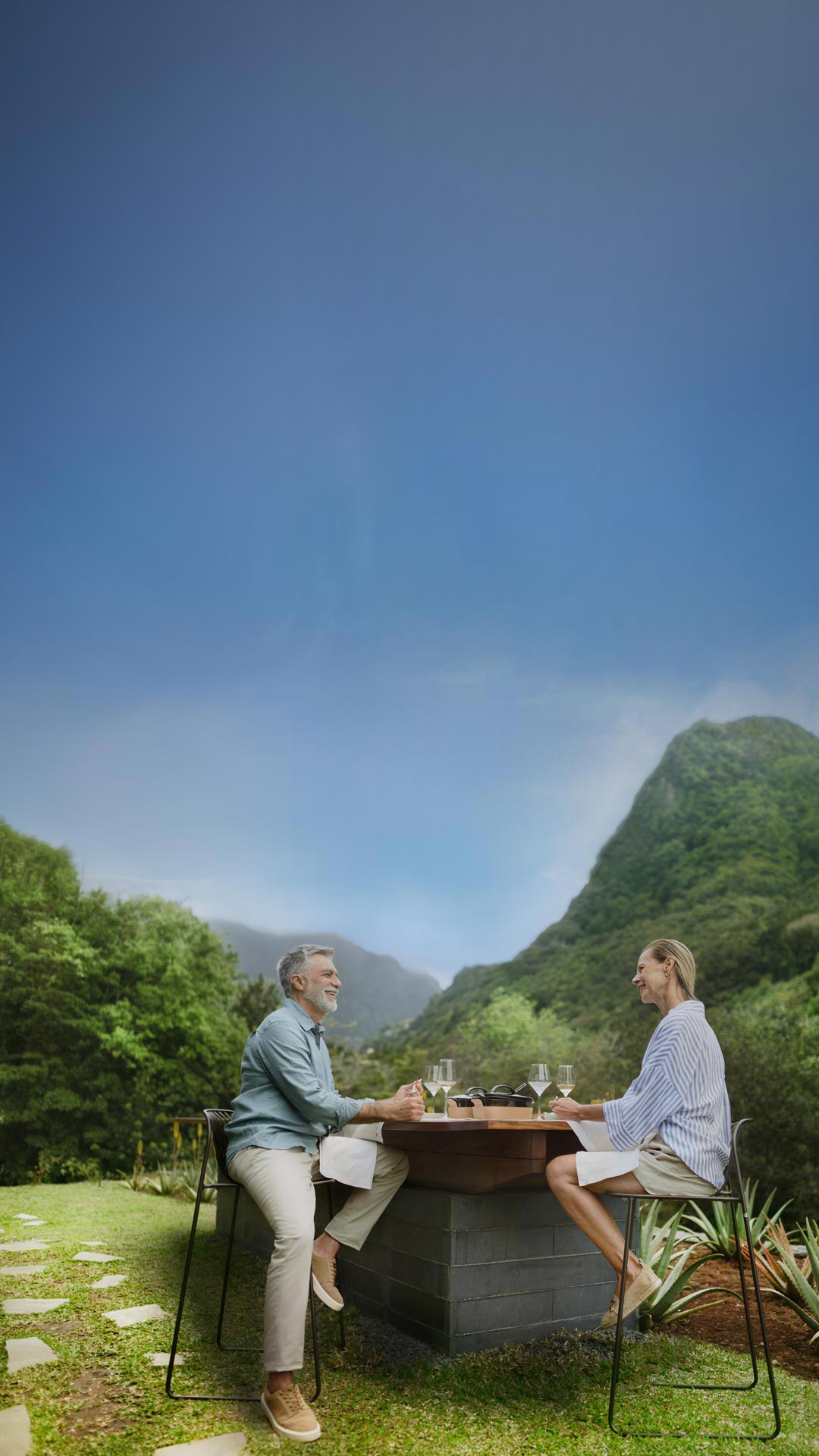 um casal numa mesa num jardim a desfrutar de um copo de vinho