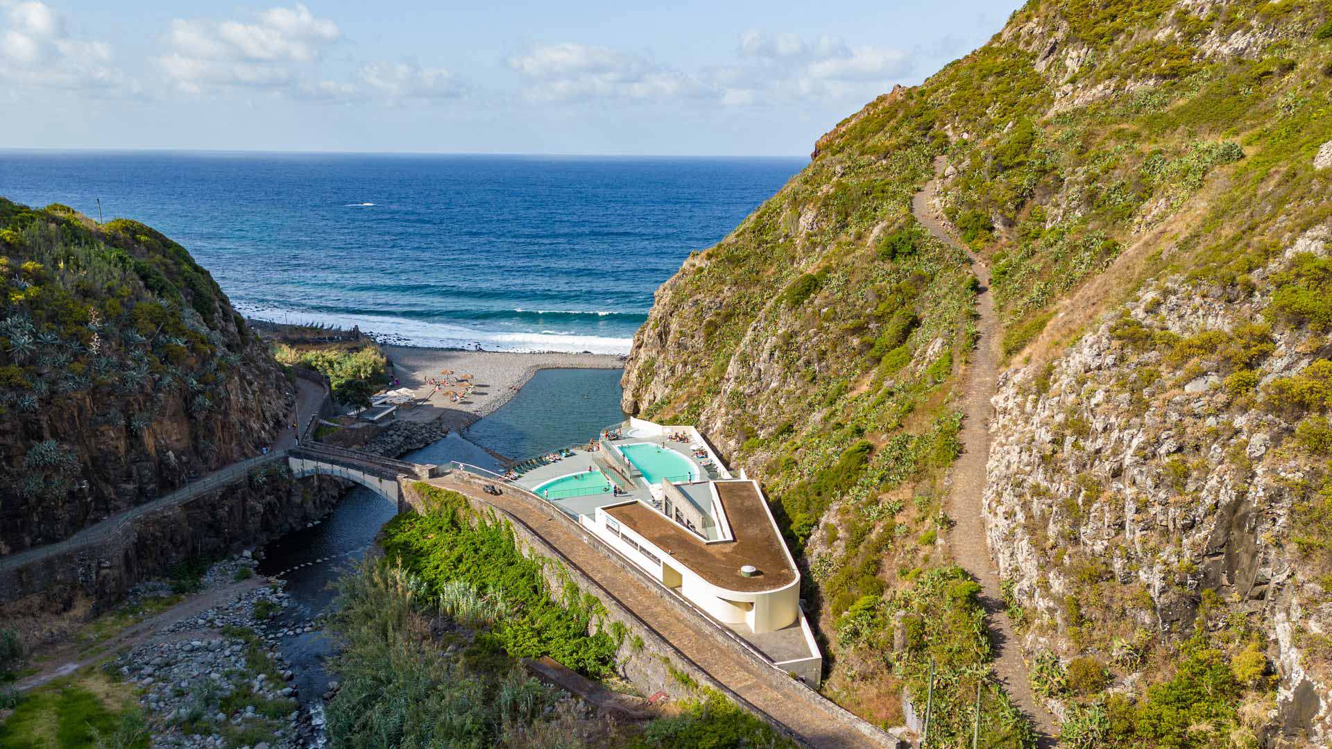 Sentier sur la montagne avec vue sur piscines et mer à Madère.
