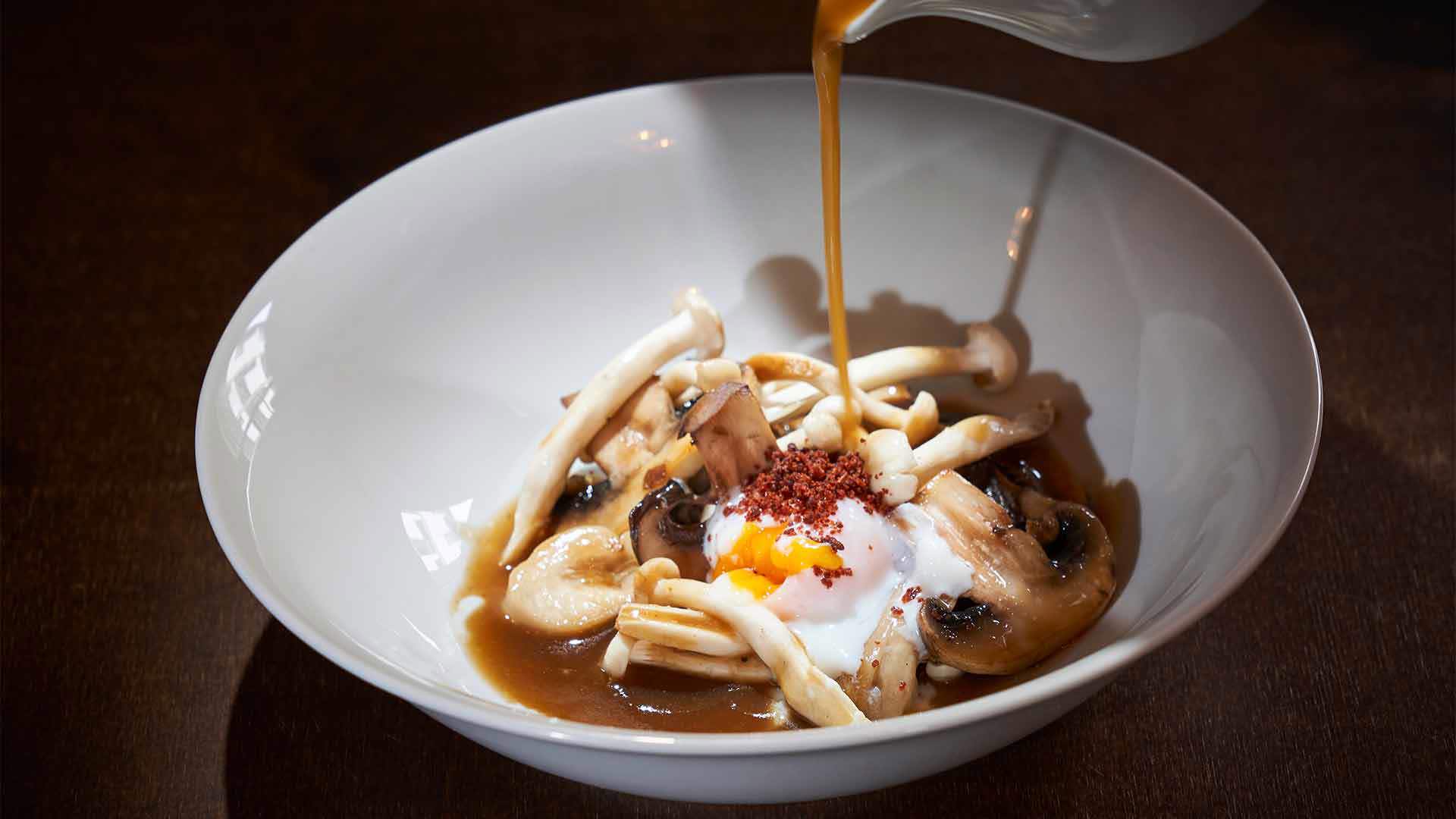 Teller mit Essen, Ei und Sauce servierbereit.