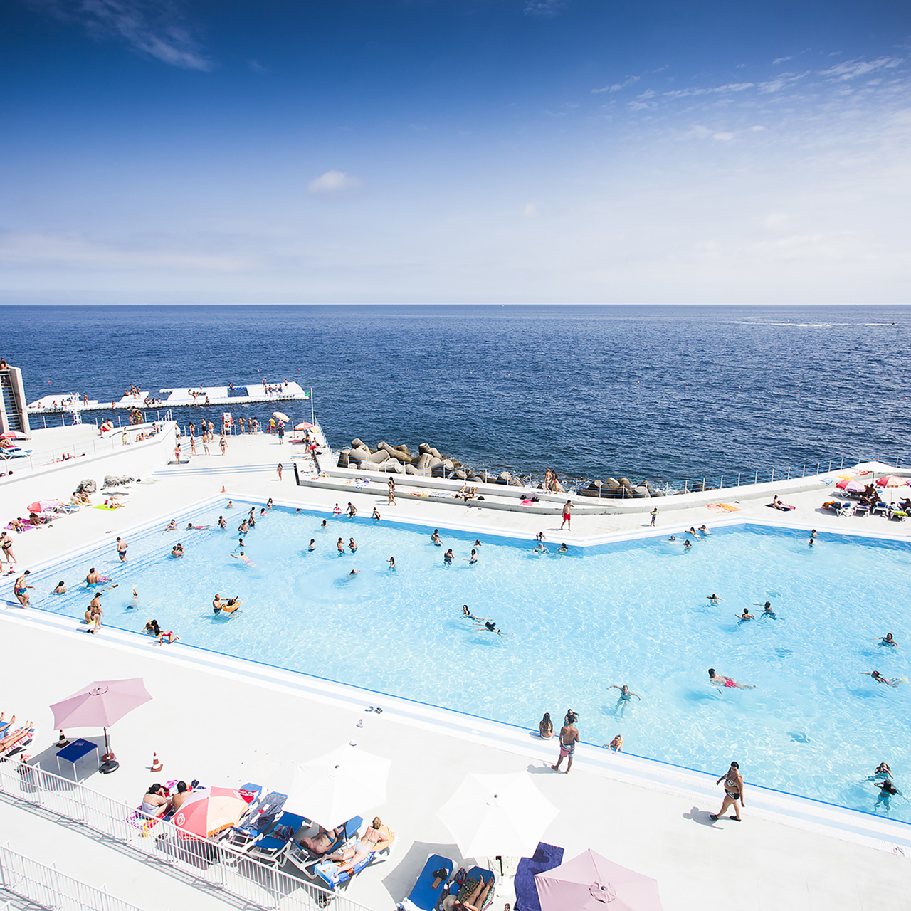Piscina con personas junto al mar en Madeira.
