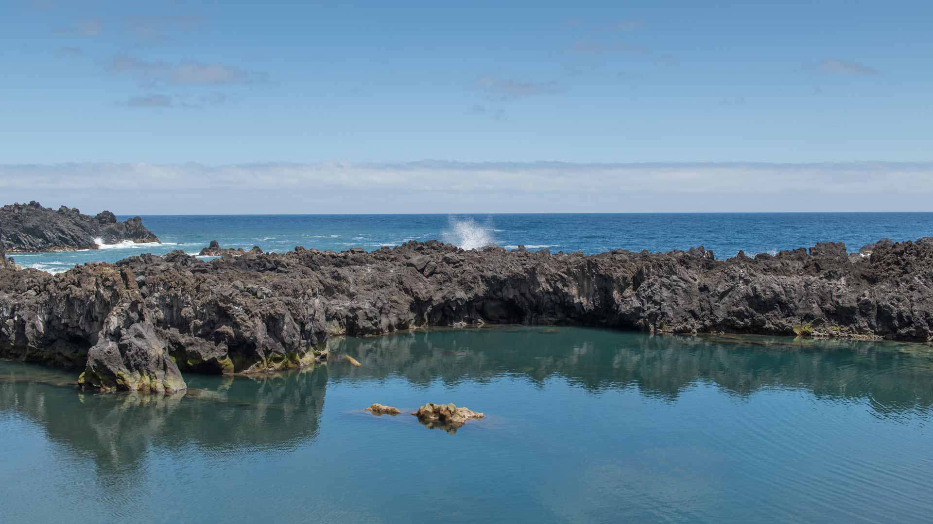 Piscine naturelle entourée de rochers avec vue sur la mer à Madère.