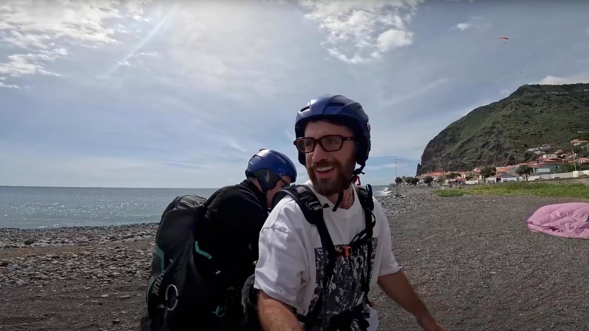 Mann mit Gleitschirm am Boden, mit Helm.