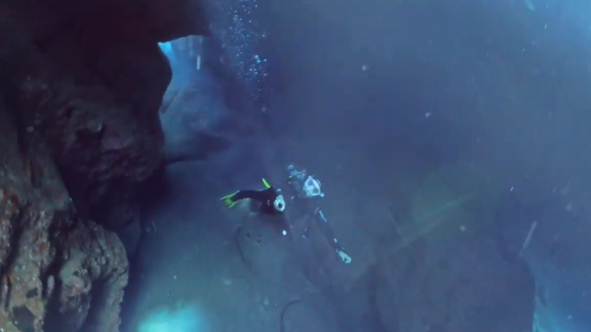 Taucher erkundet eine Felsspal.