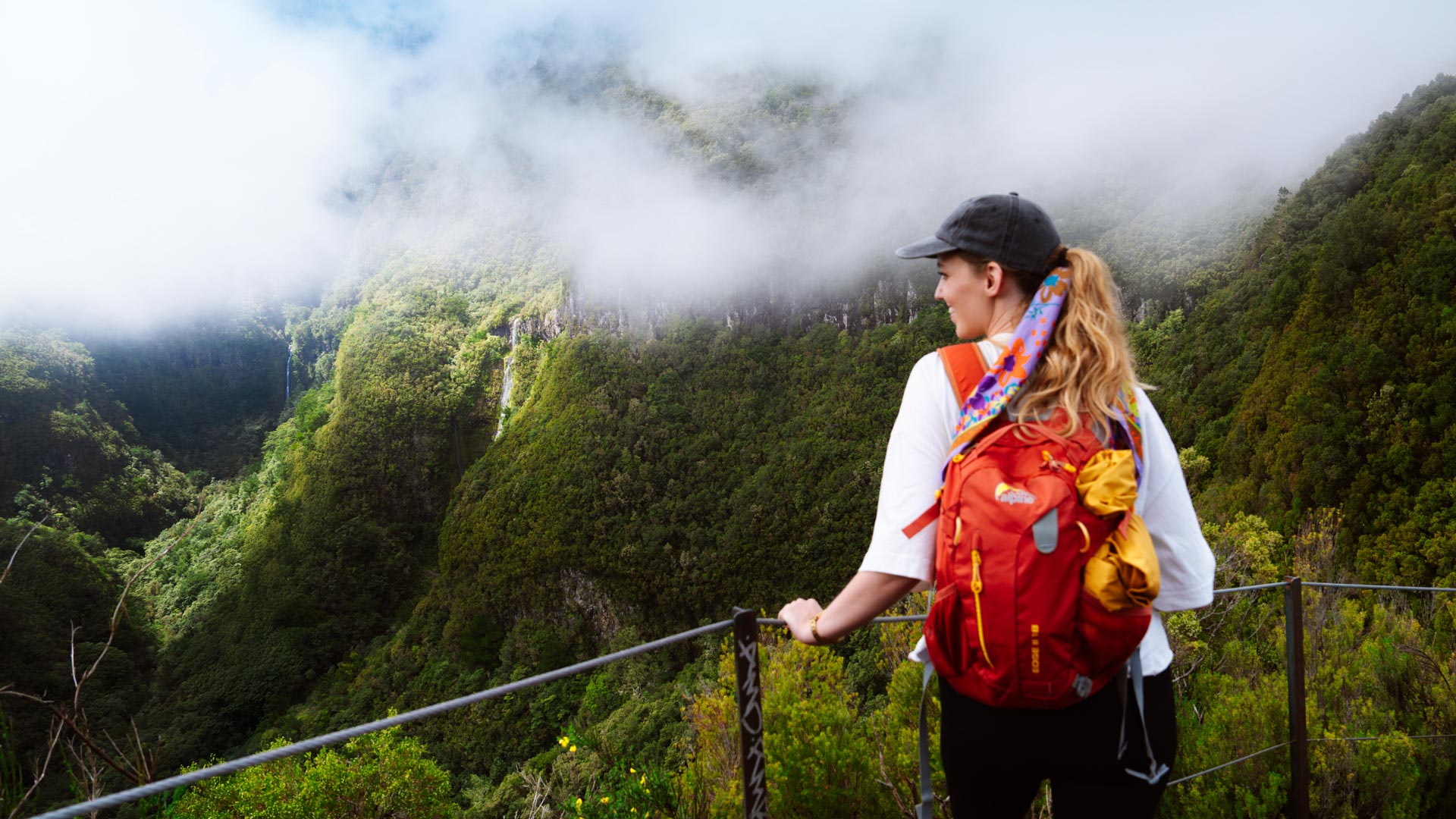 Frau wandert mit Rucksack durch die Vegetation Madeiras.