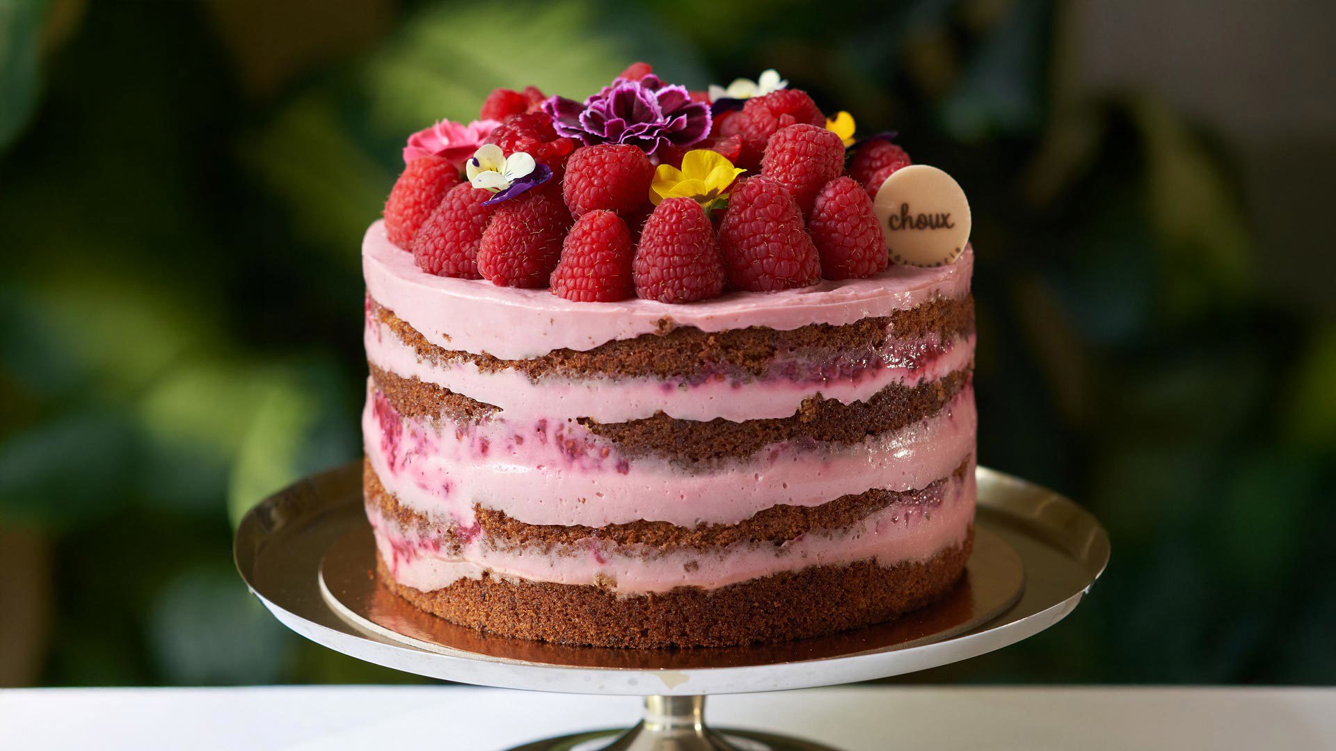 Bolo de camadas com creme e morangos no topo na Choux Pâtisserie