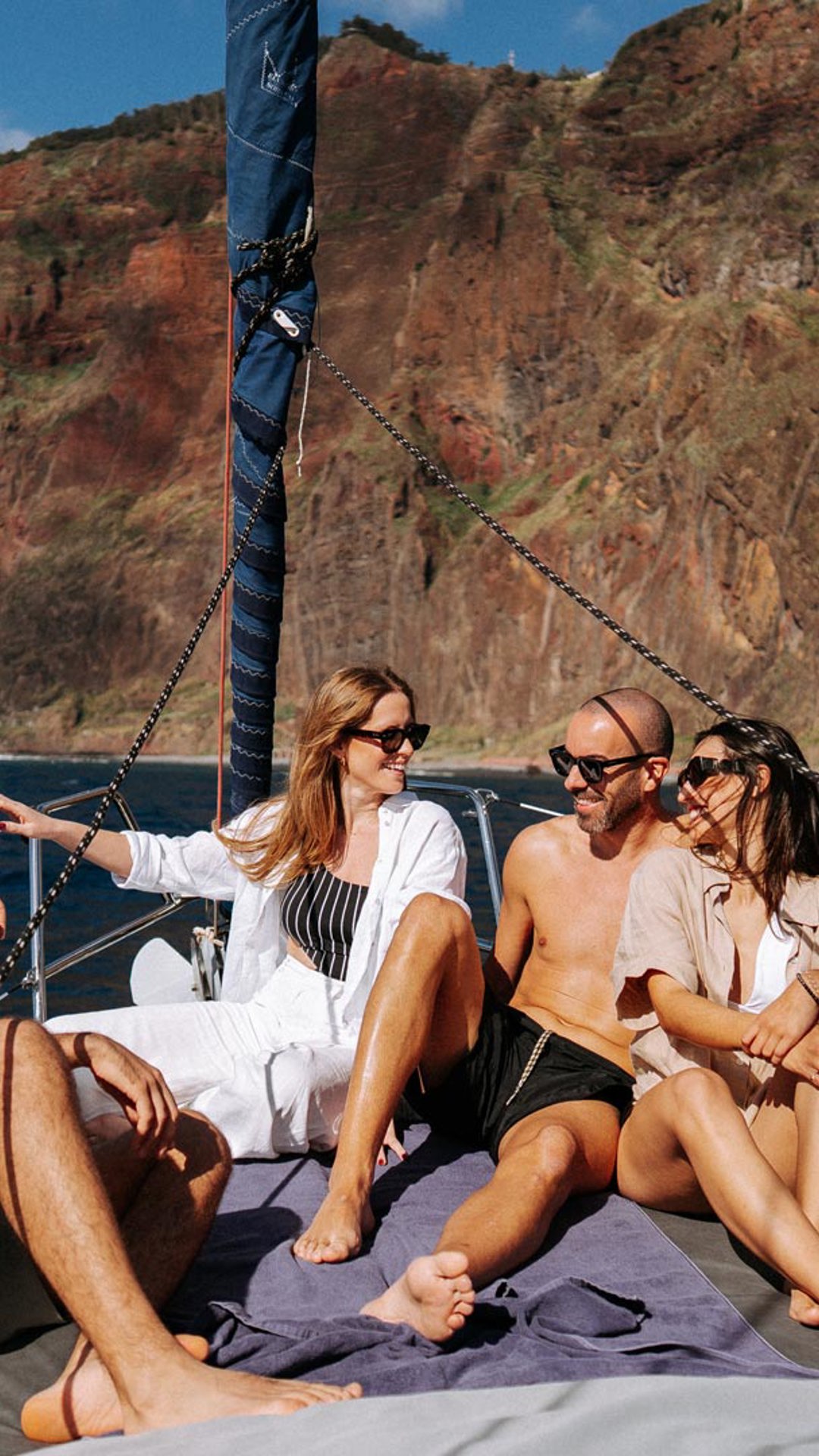 Two couples seated on a boat tour at sea, with Madeira’s coastline in the background.