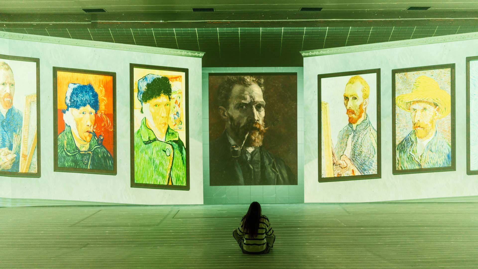 Frau sitzt vor großformatigen Gemälden