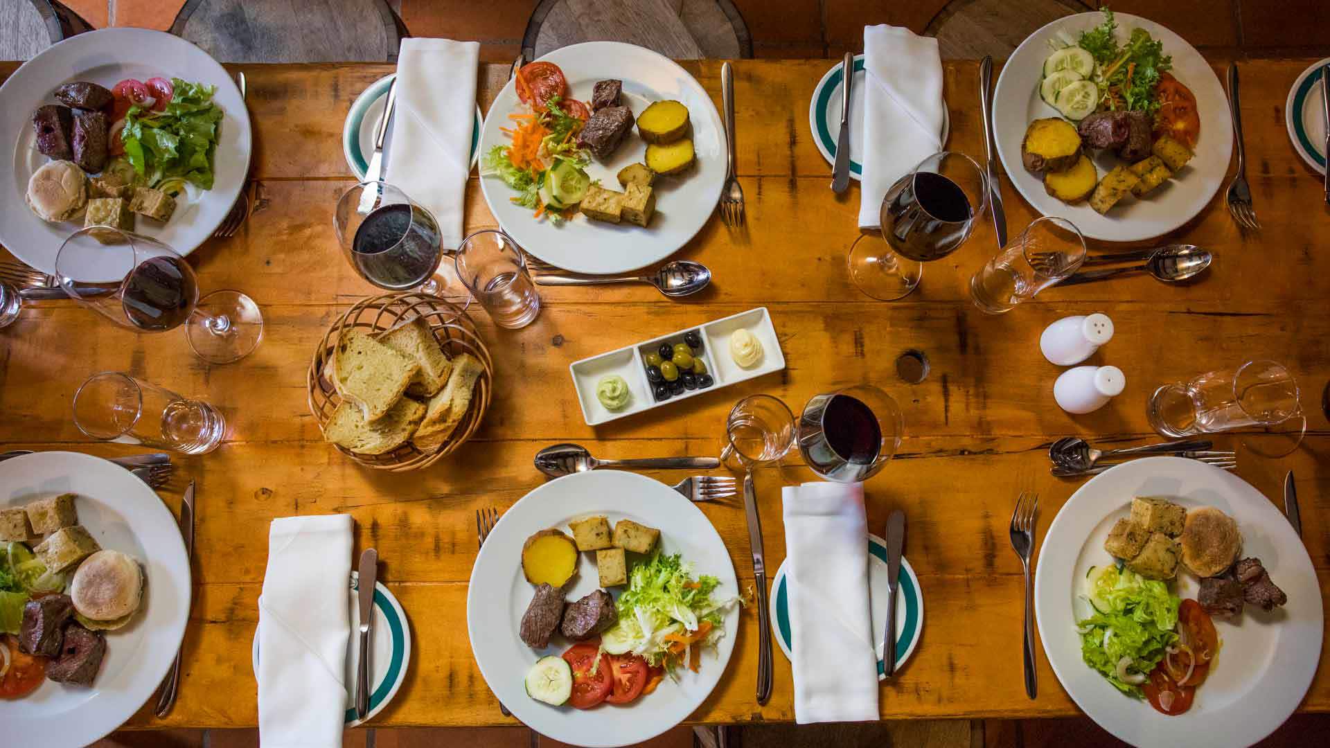 Mesa preparada com pratos e copos de vinho para uma refeição na Ilha da Madeira.
