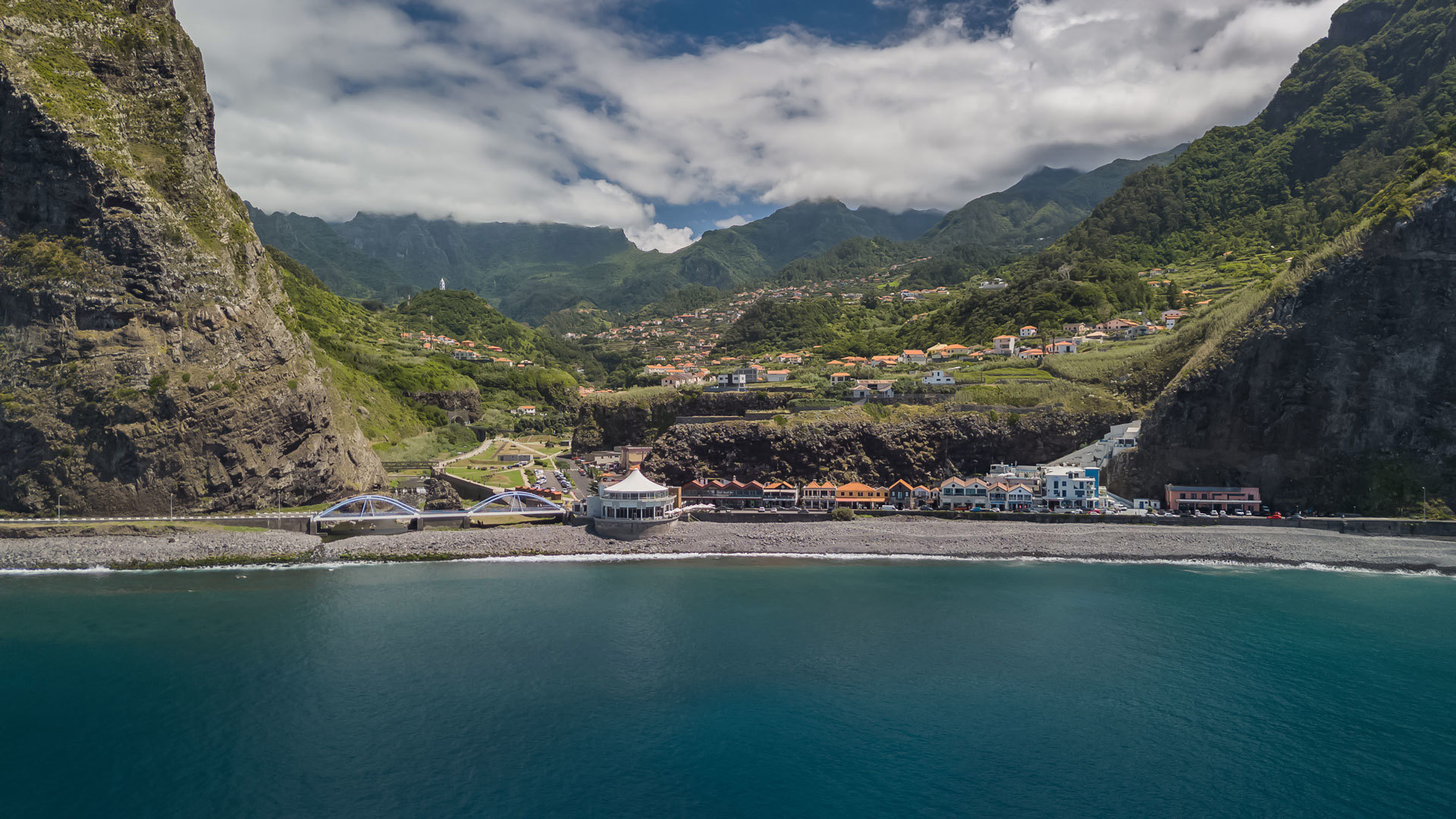 Mer avec des maisons dans la vallée parmi les nuages à Madère.
