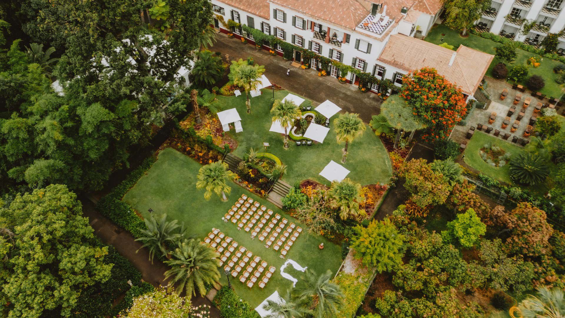 Vista aérea de espaço de cerimónia de casamento ao ar livre com cadeiras e natureza.