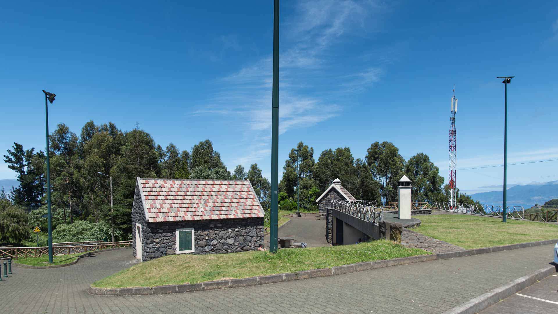 Maison en pierre avec arbres verts en arrière-plan dans un cadre naturel.