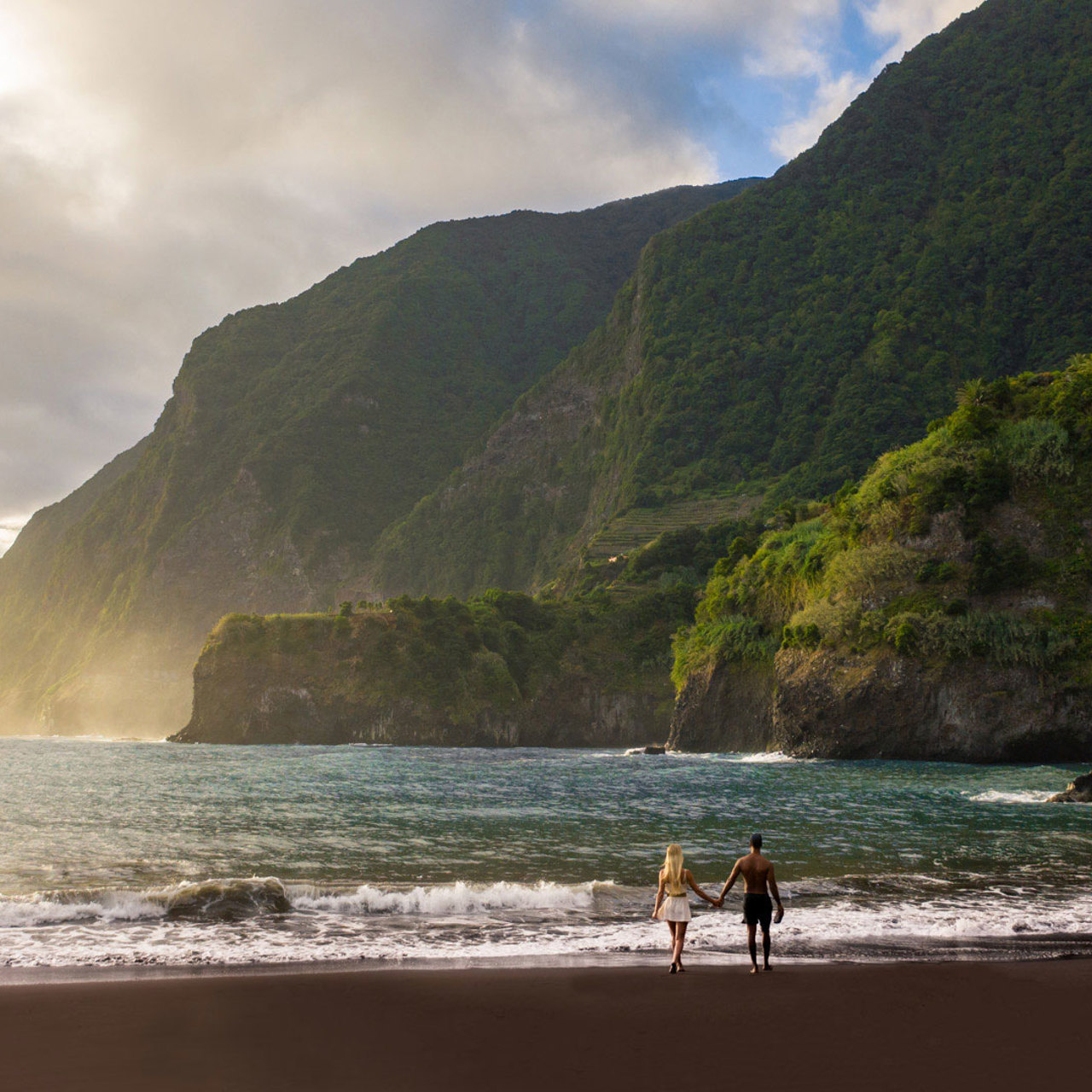 Couple on Seixal Beach on Madeira’s north coast by the sea.