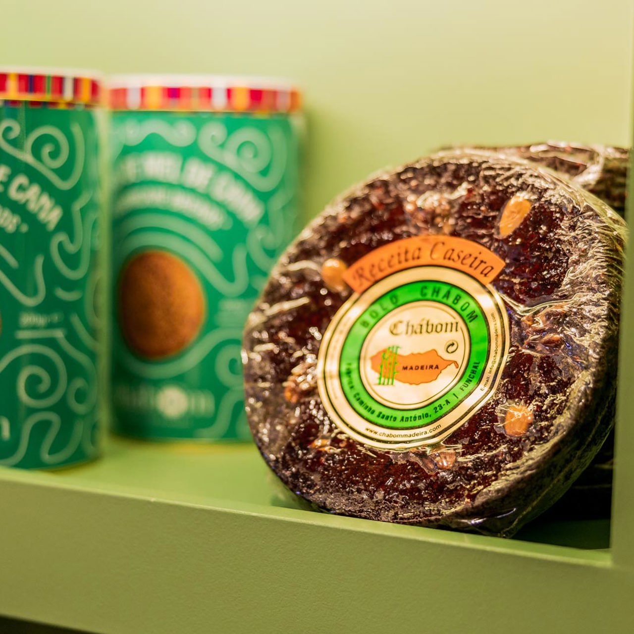 Prateleiras do Posto de Turismo da Madeira em Lisboa com broas e bolo de mel em exposição.