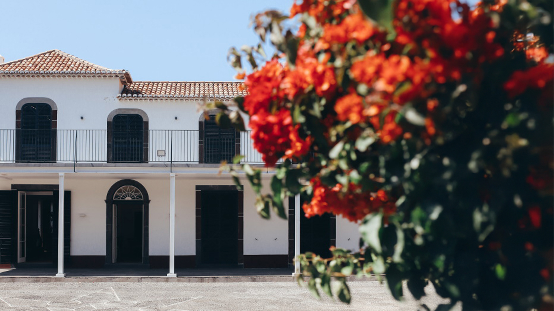 Façade de restaurant décorée avec des fleurs rouges.