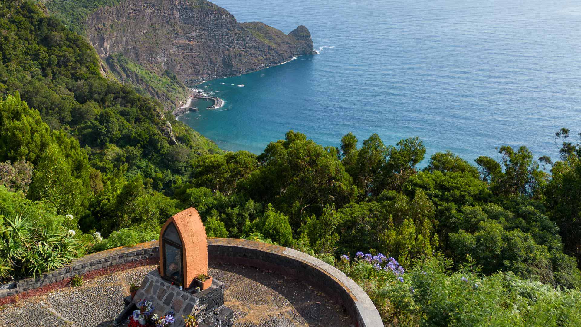 Mirador con vegetación verde y vista al mar.
