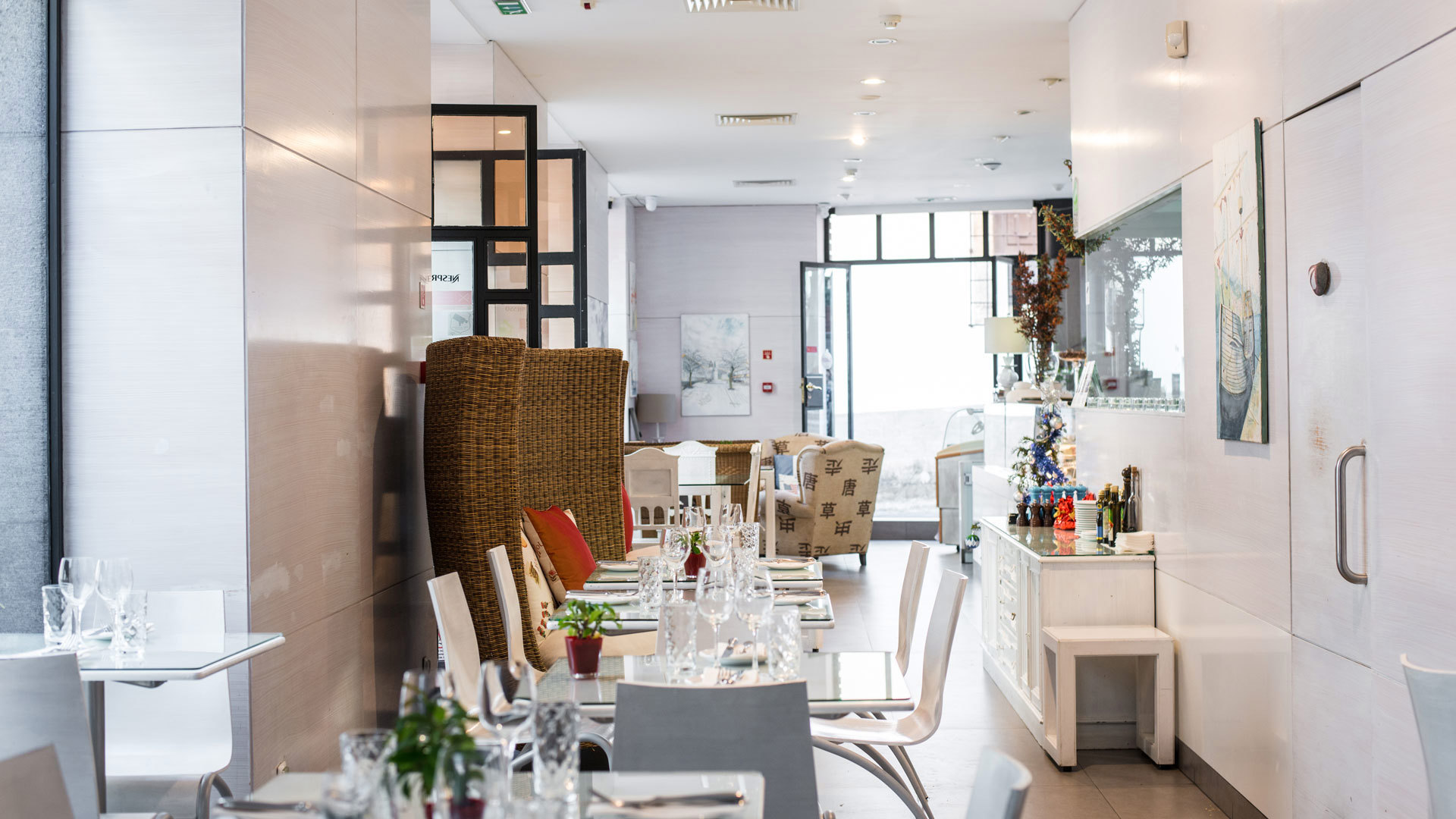 Tables with glasses and furniture lit by natural light.