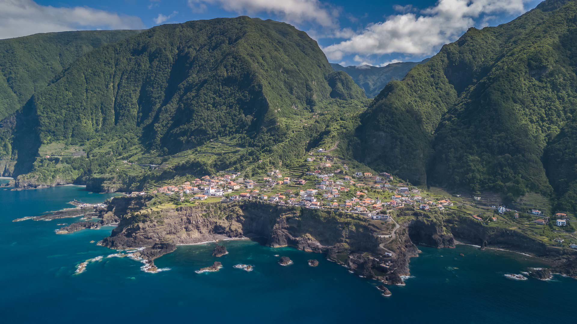 Foto aérea de la costa de Madeira con casas entre la naturaleza.