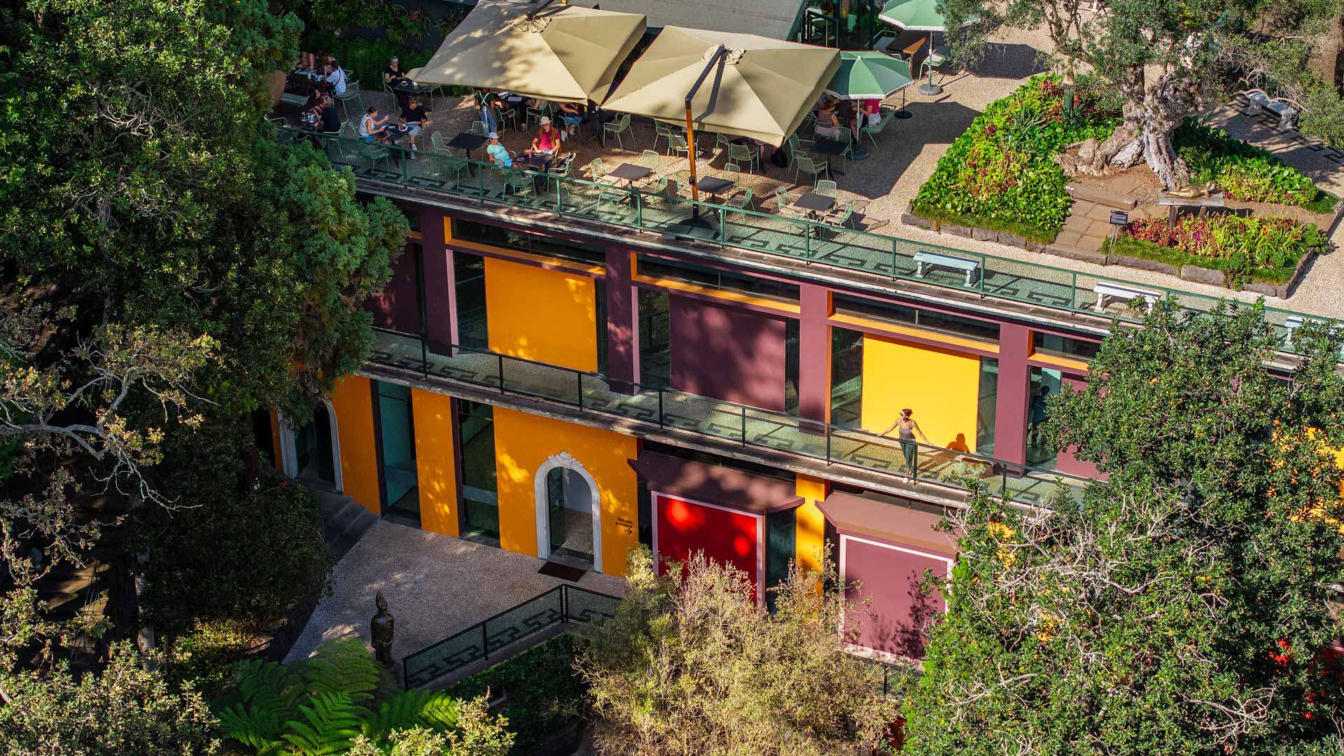 Außenpavillon des Monte Palace Museums mit bunten Wänden, umgeben von Vegetation.