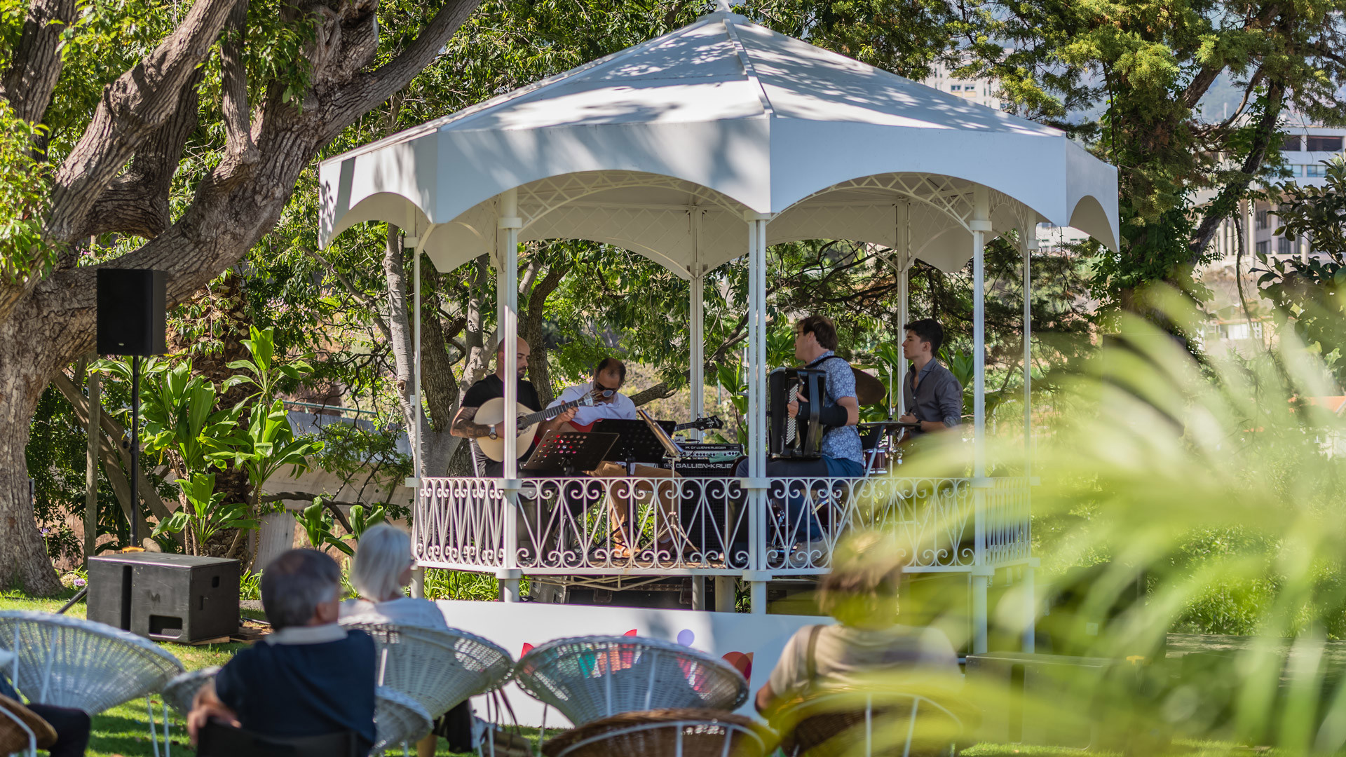 Banda actuando en un quiosco en el jardín.