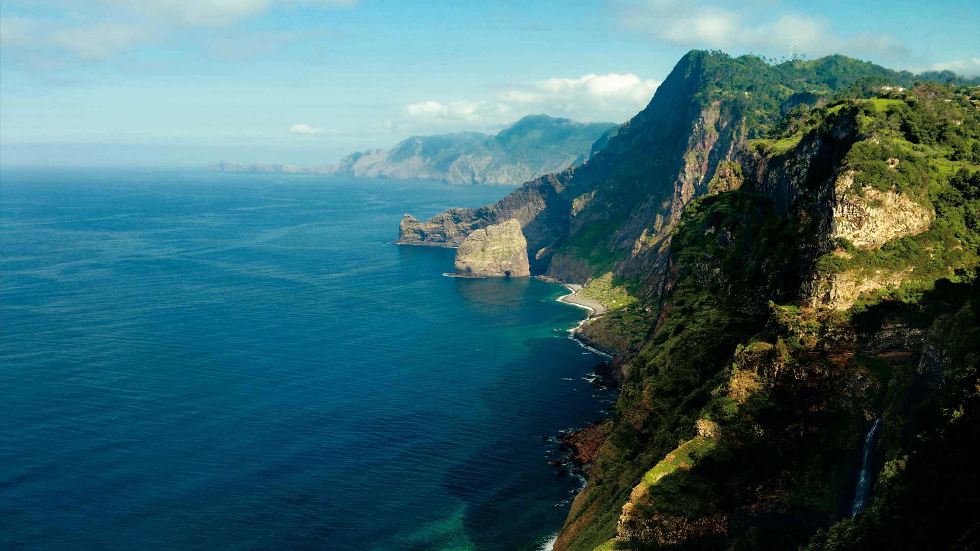 Paisaje con montañas verdes y mar en Madeira.
