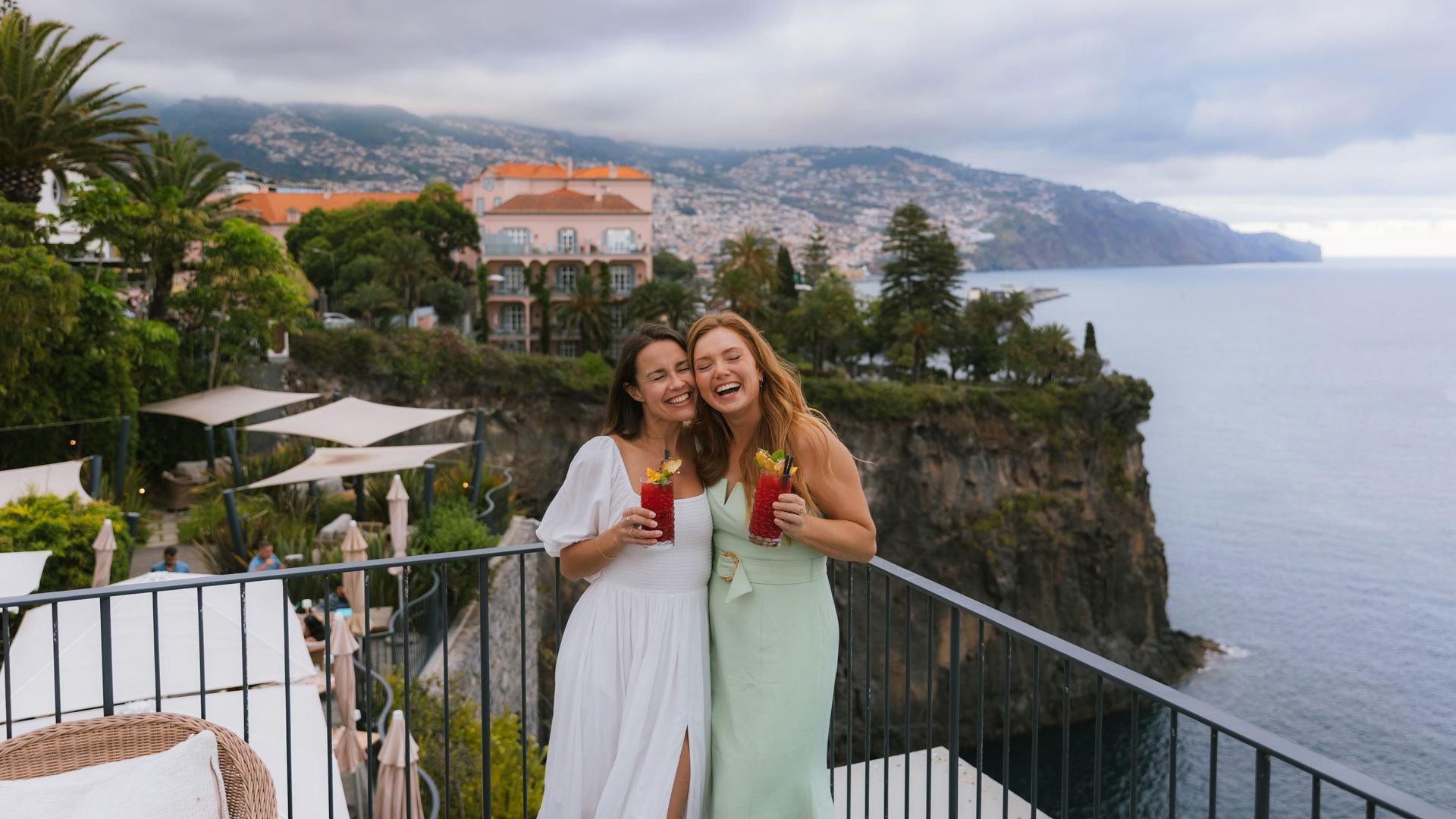 Zwei Freundinnen trinken mit Blick auf die Küste Madeiras.