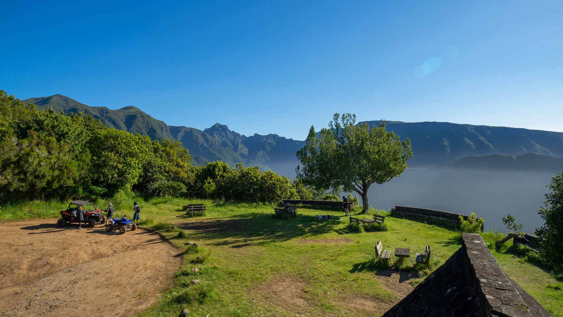 Jardin avec bancs, personnes et vue sur les montagnes à Madère.