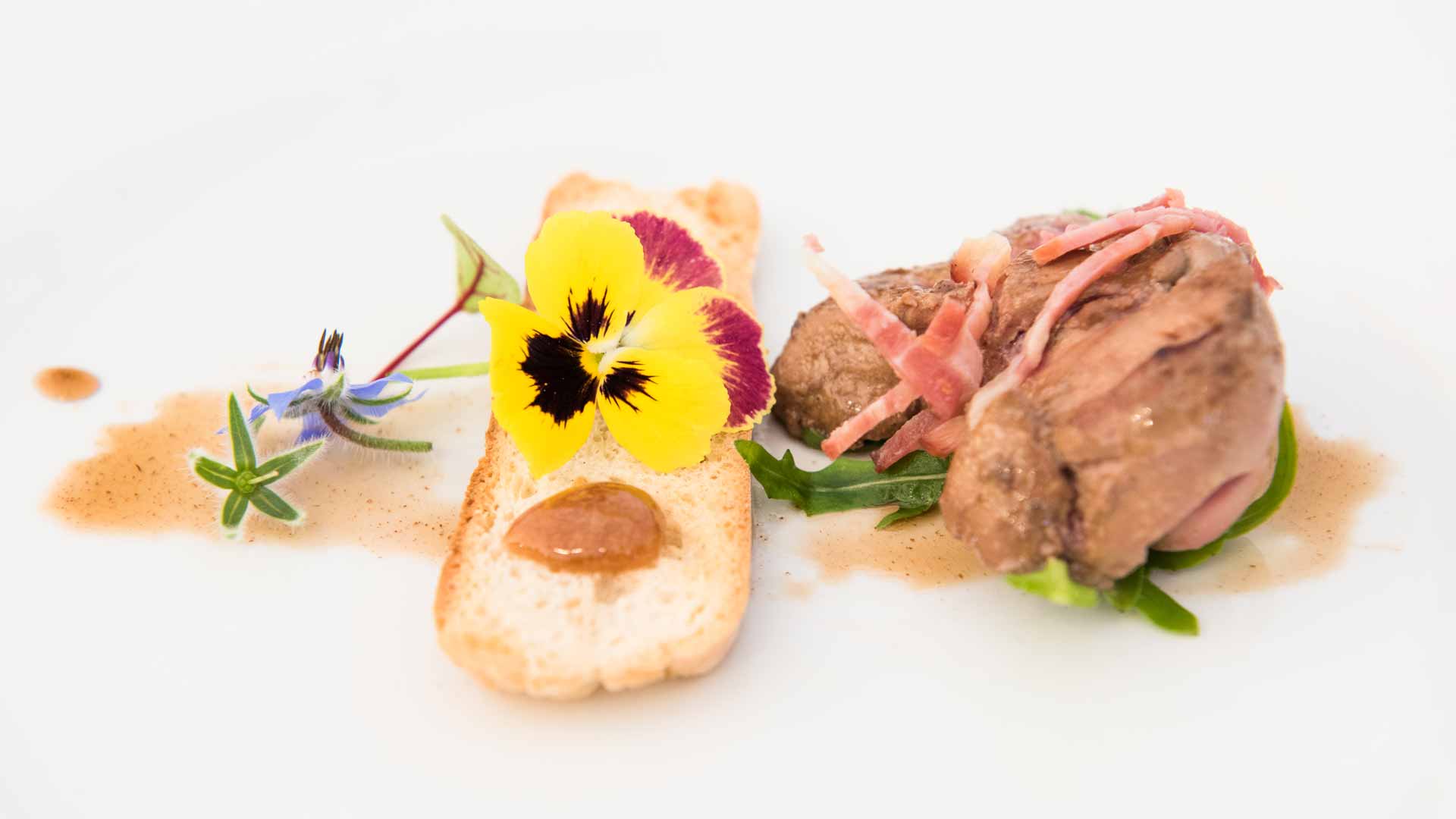 Plat de viande dressé sur une assiette blanche dans un style de cuisine contemporaine.