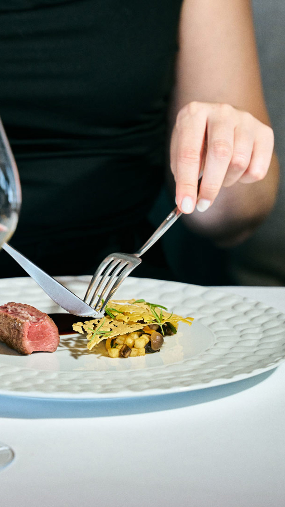 Frau genießt ein modernes gastronomisches Erlebnis mit einem Glas Wein auf Madeira.