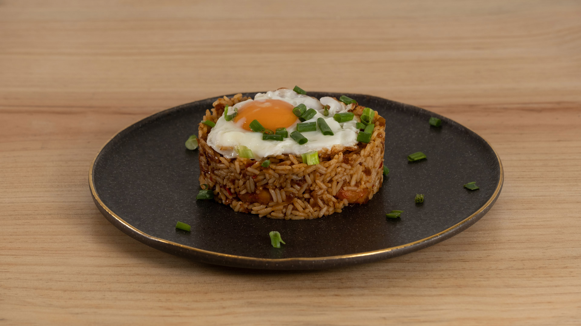 Prato com base de arroz e ovo estrelado por cima.