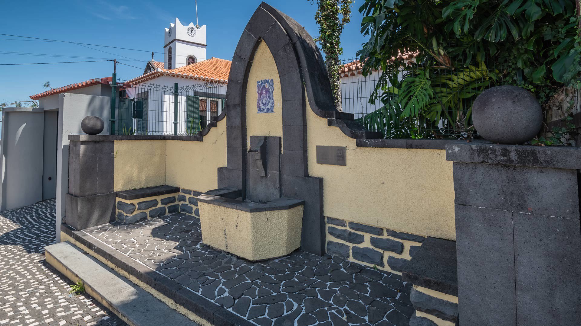 Häuser und Kirche in der Nähe des gelben Steinbrunnens auf Madeira.