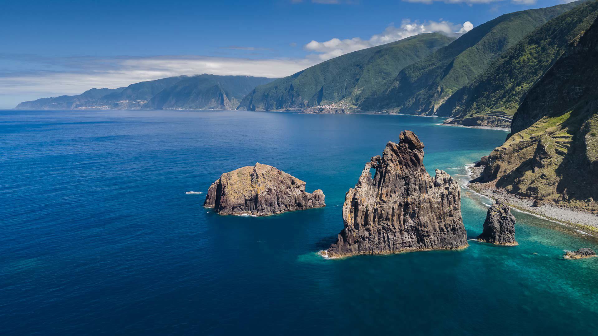 Islets in the sea with mountains in the background in Madeira.