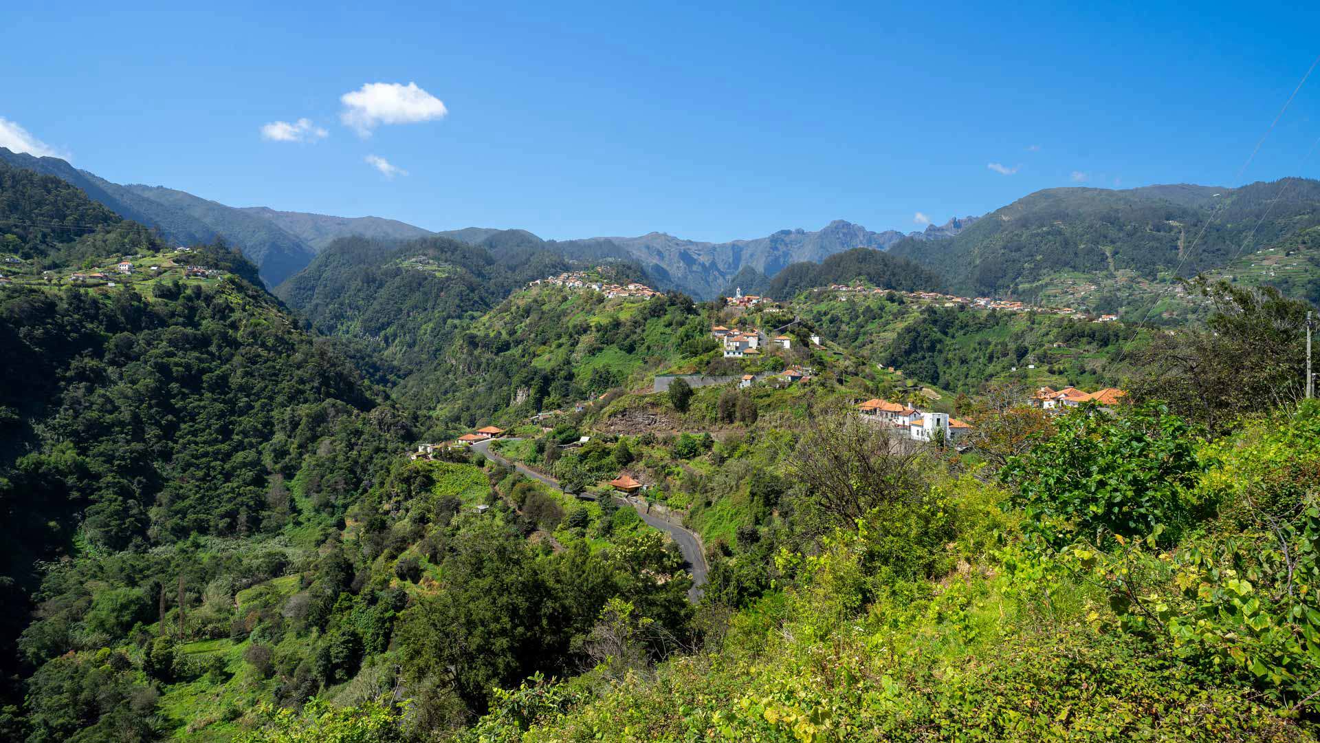 Grüne Berge mit Häusern in Madeira.