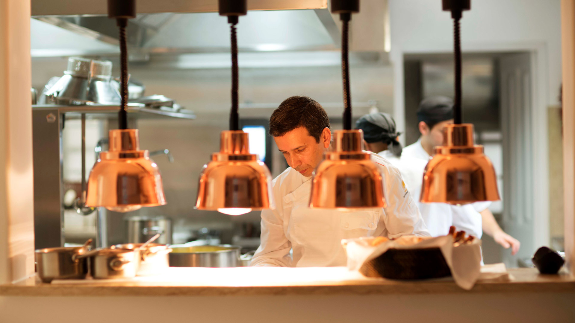 Chef's counter with lamps and culinary utensils.