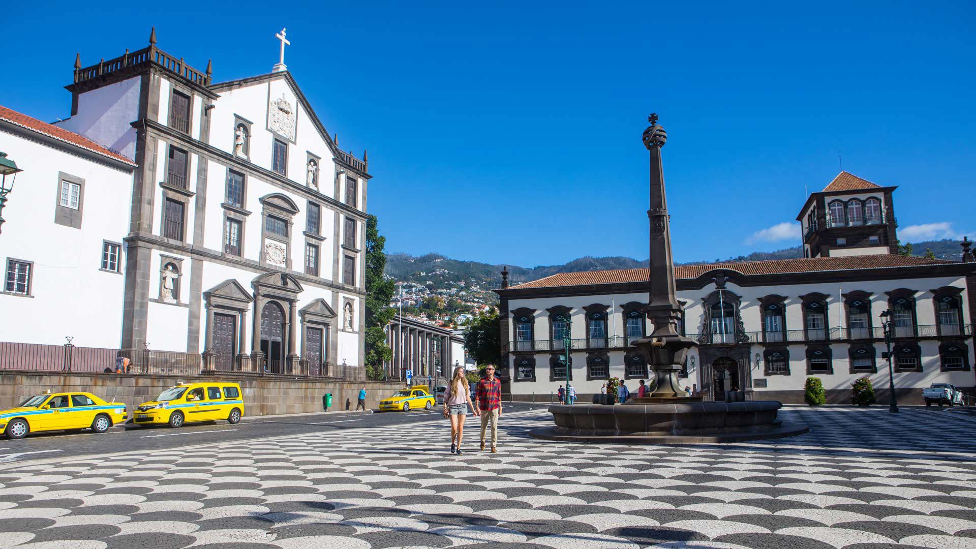 Young couple in a square with taxis, church and fountain.