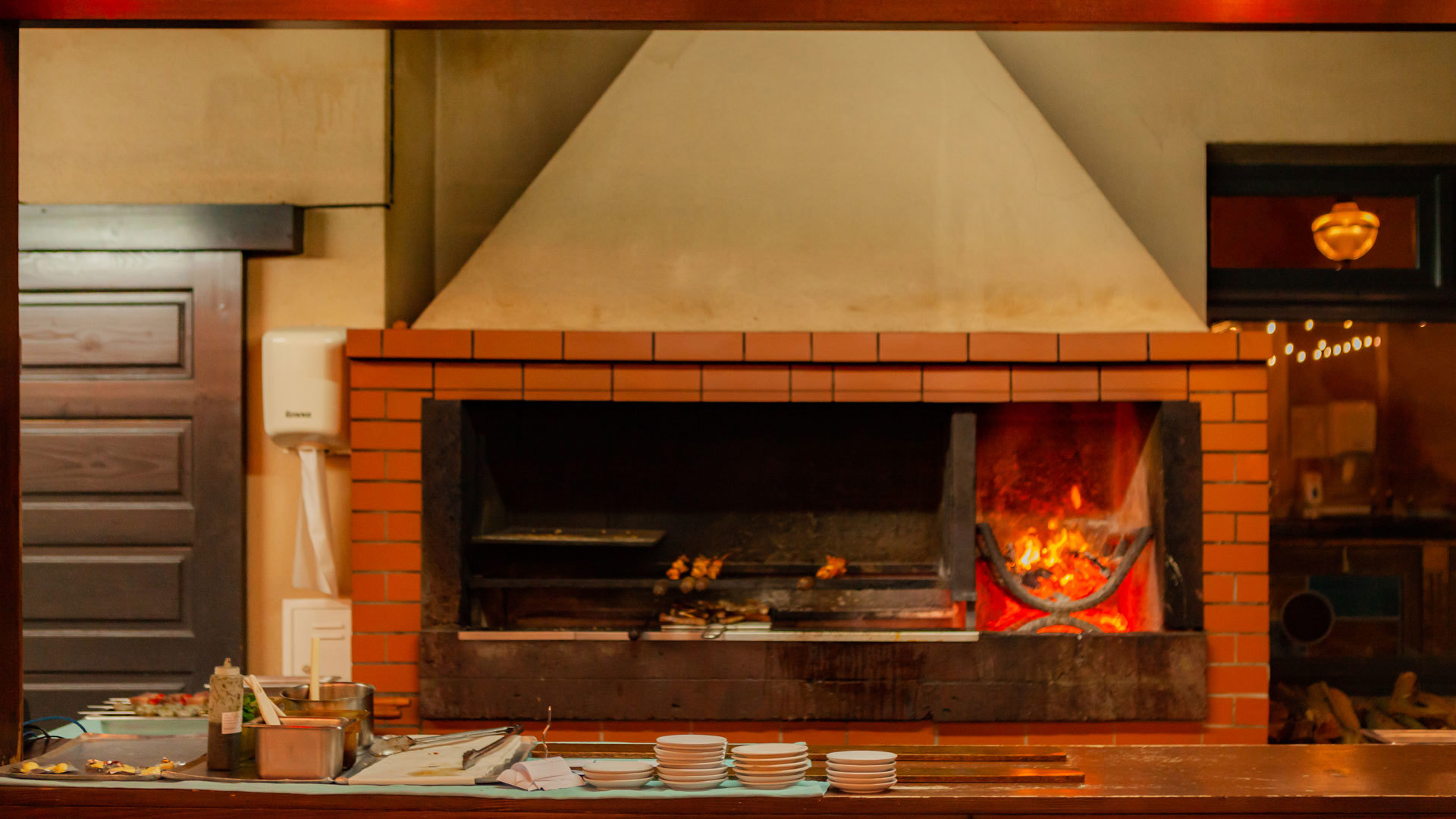 Fireplace with fire and meat skewers roasting.