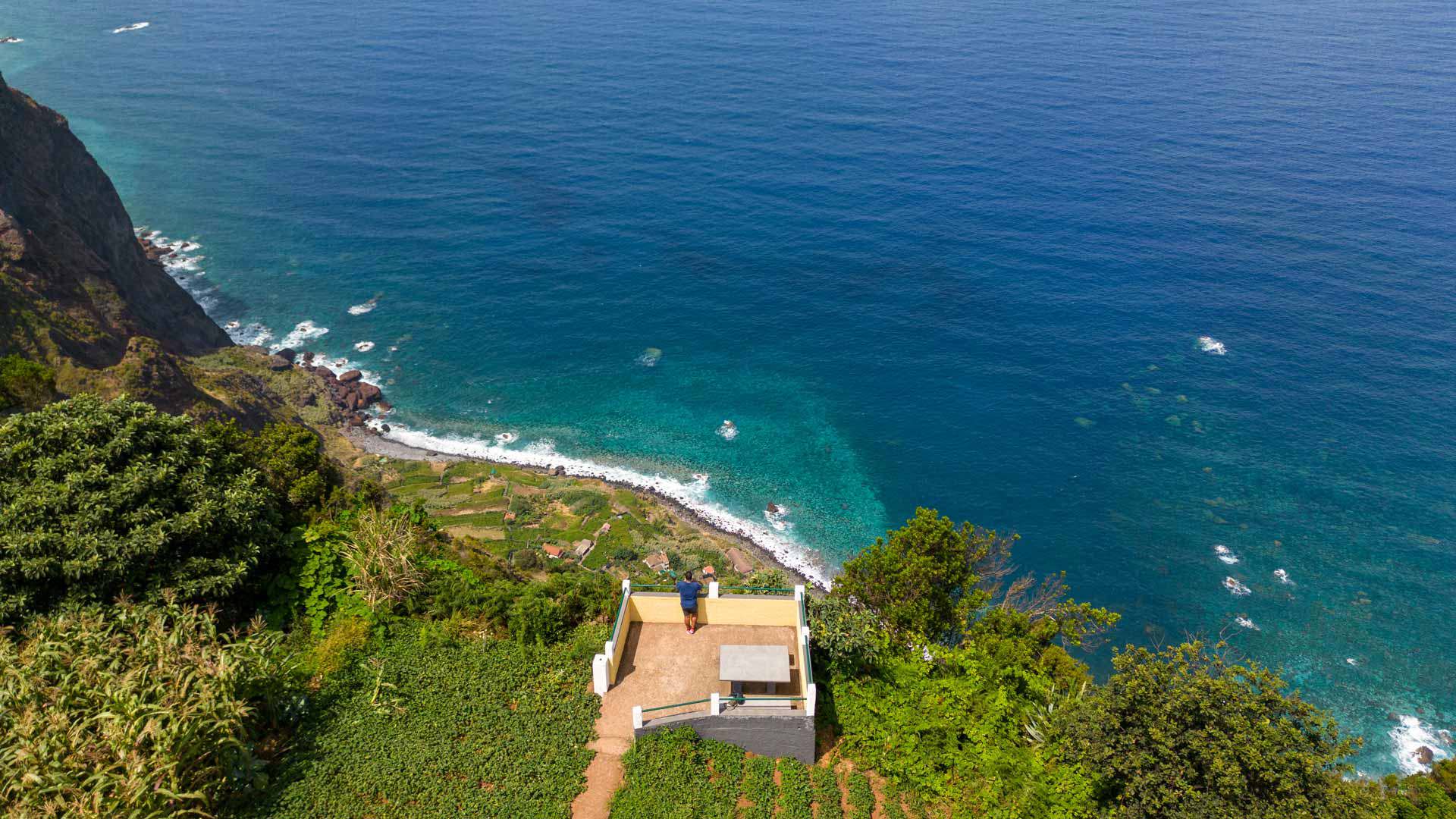 Casa en terrenos verdes en la ladera con vista al mar.