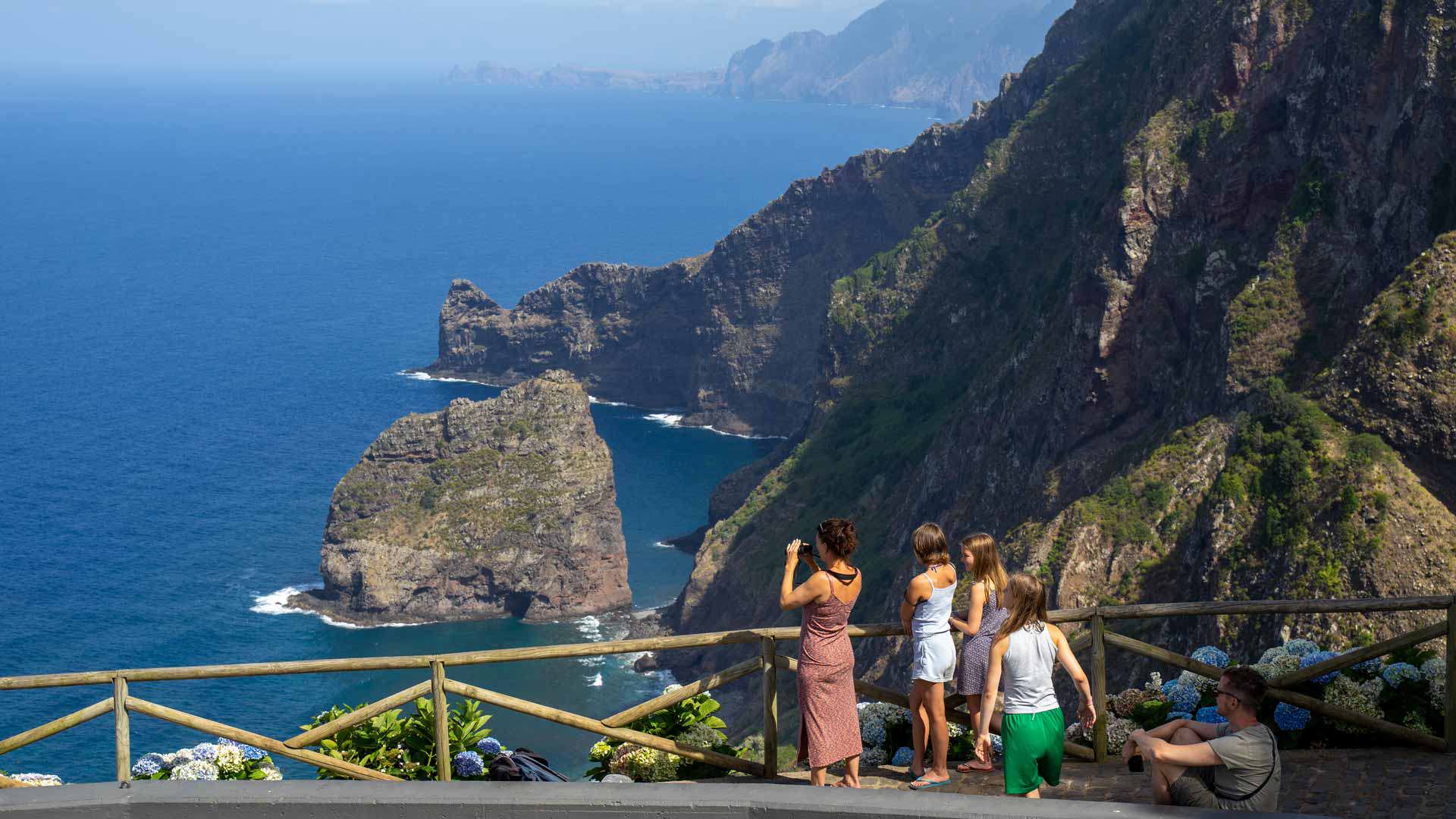 Personas tomando fotos del paisaje con vista al mar en Madeira.
