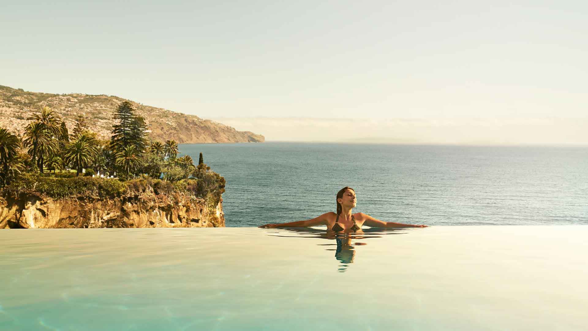 Femme dans la piscine à débordement de l’hôtel PortoBay, sur l'île de Madère.