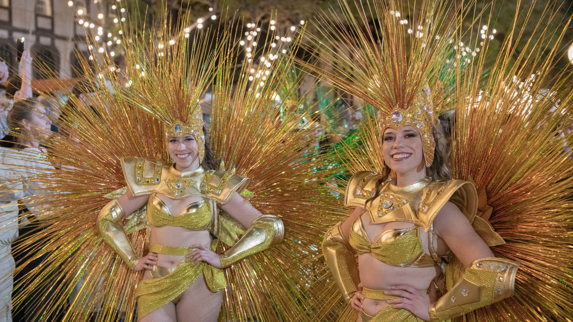 Women in costume taking part in a Carnival parade at night in Funchal, Madeira.