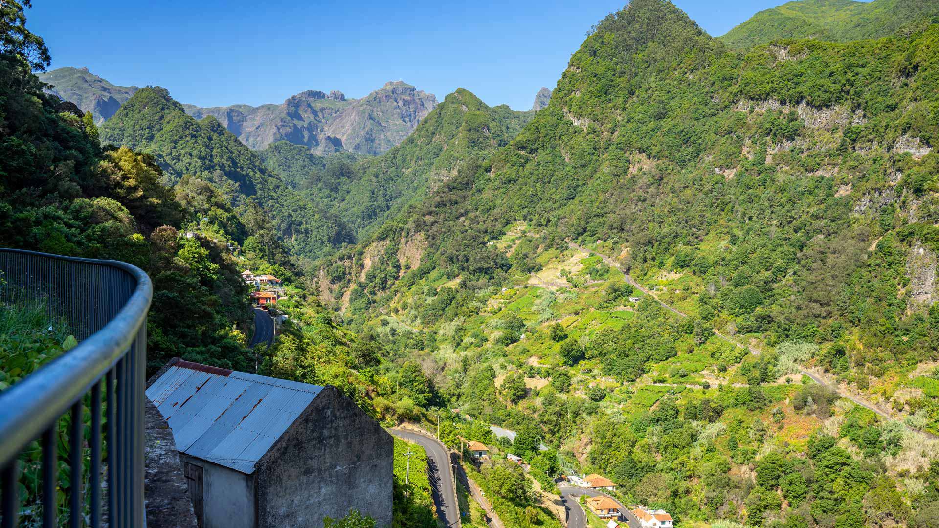 Zaun bei Haus mit Aluminiumdach nahe einem Berg.