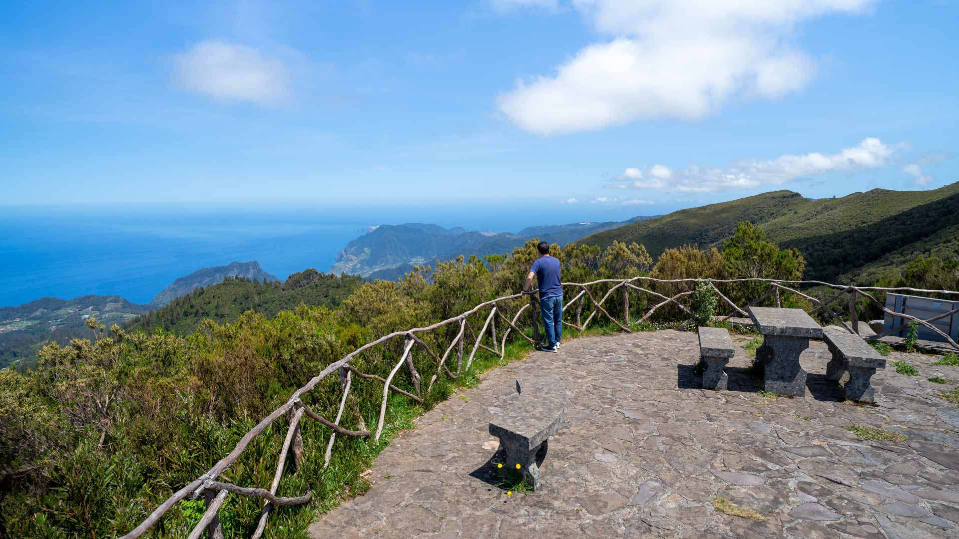Aussichtspunkt mit Steinbänken und Blick auf Berge und Meer.
