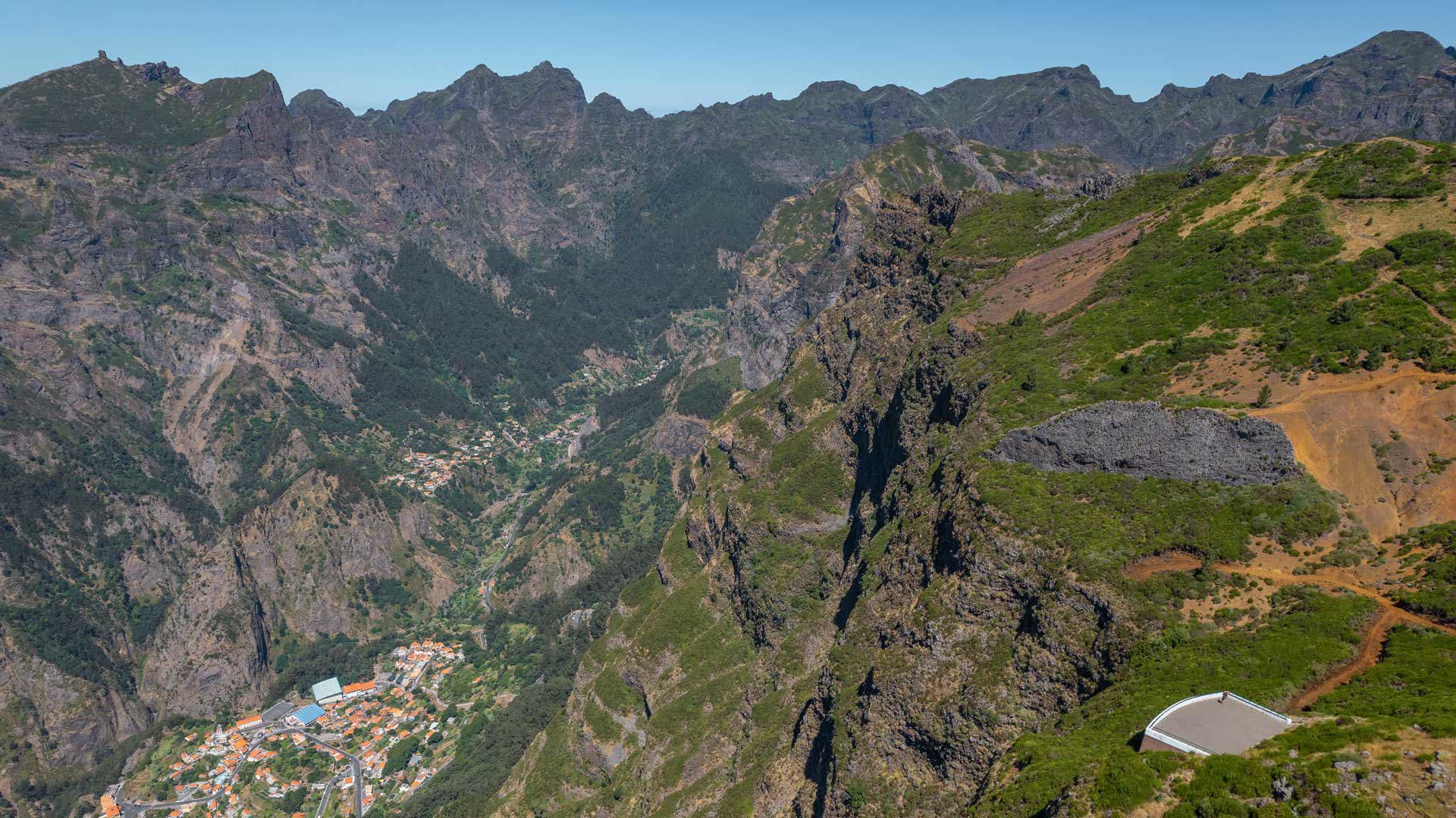 Aussichtspunkt Paredão mit Blick auf Curral das Freiras, Berge, Vegetation und blauem Himmel.  Select 87 more words to run Humanizer.