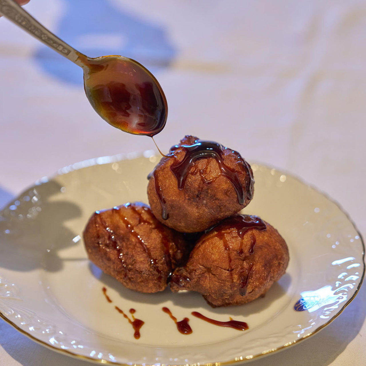 Teller mit Malassadas, überzogen mit Zuckerrohrhonig, einer traditionellen Süßspeise der Insel Madeira.