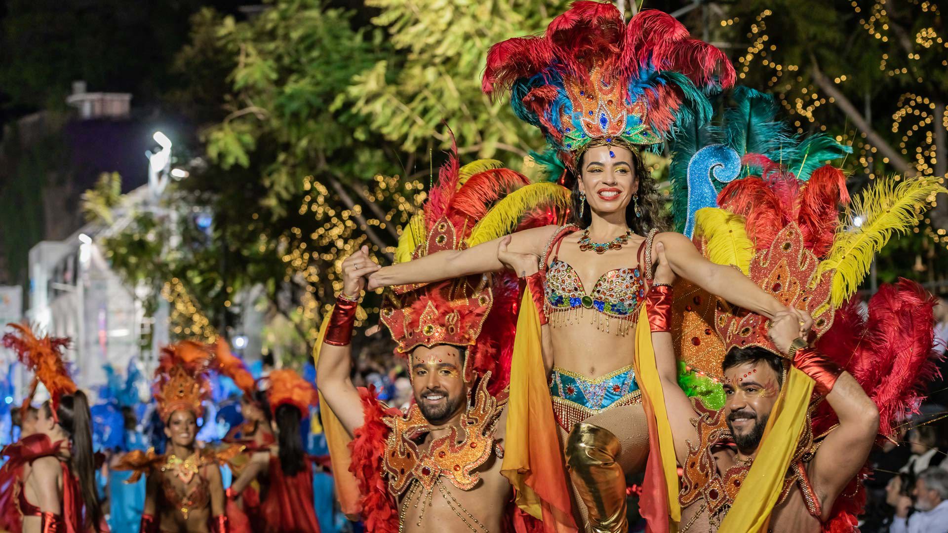 Women in costume taking part in a Carnival parade at night in Funchal, Madeira.