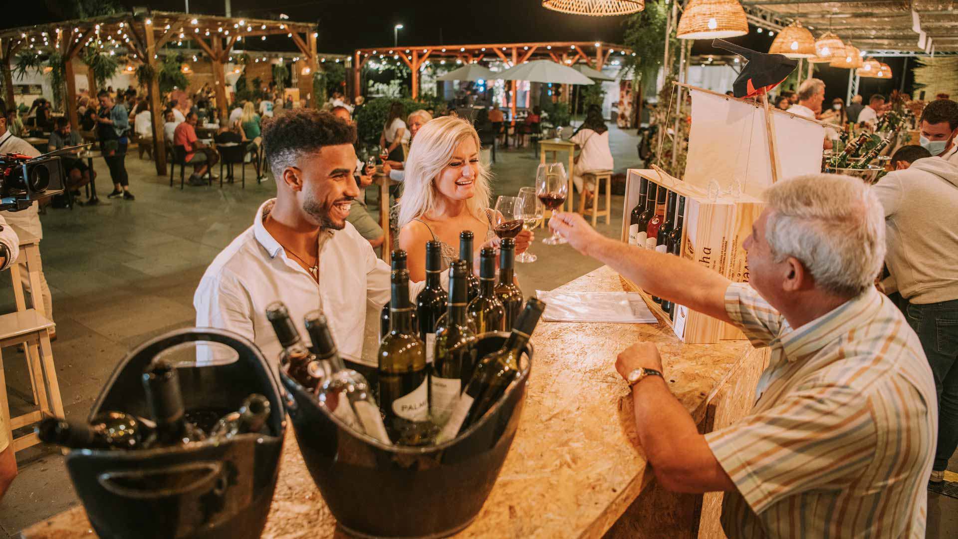 Des personnes portant un toast avec du vin, sur l'île de Madère.