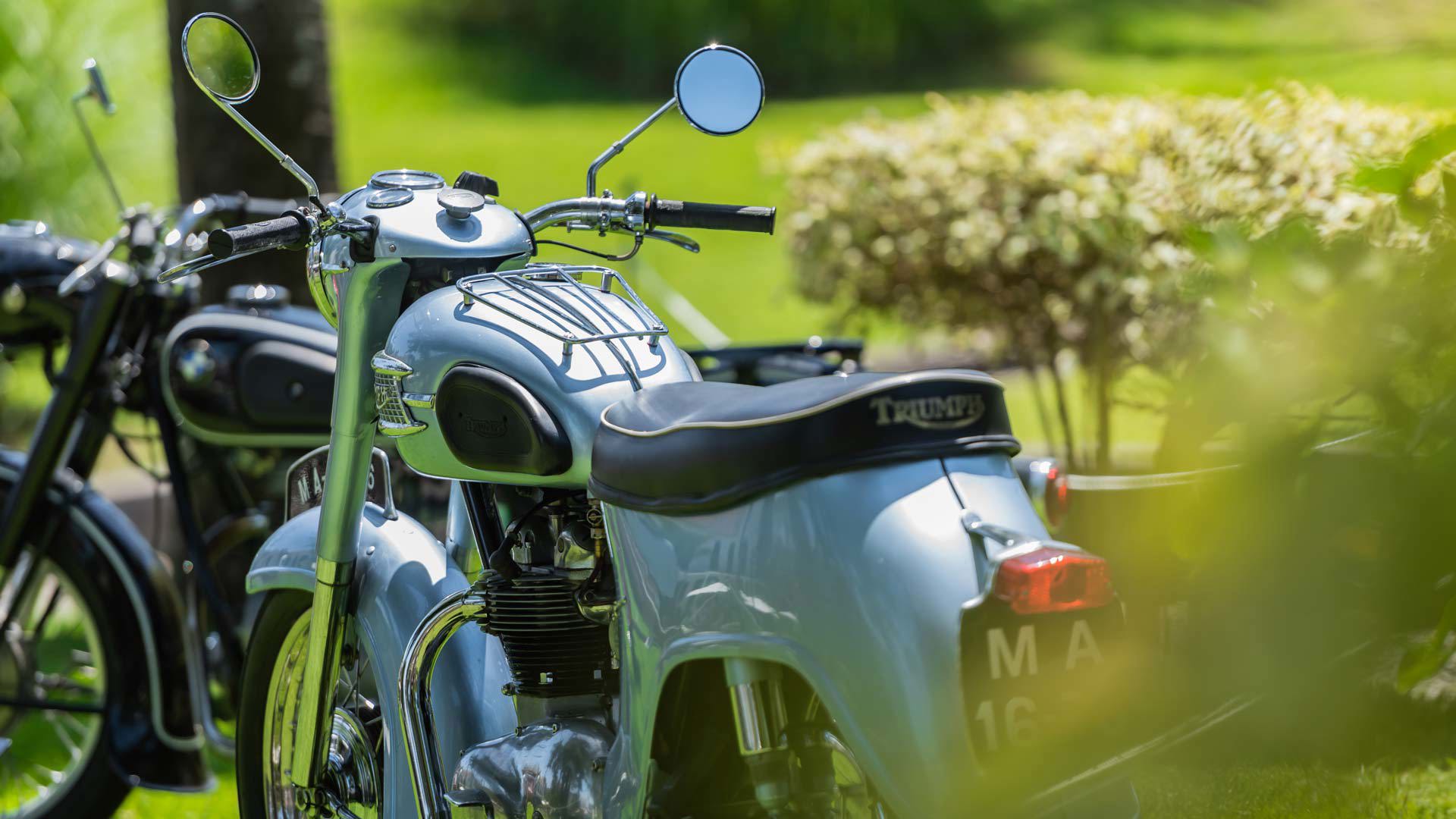 Moto clásica expuesta en un jardín de la Quinta da Magnólia.