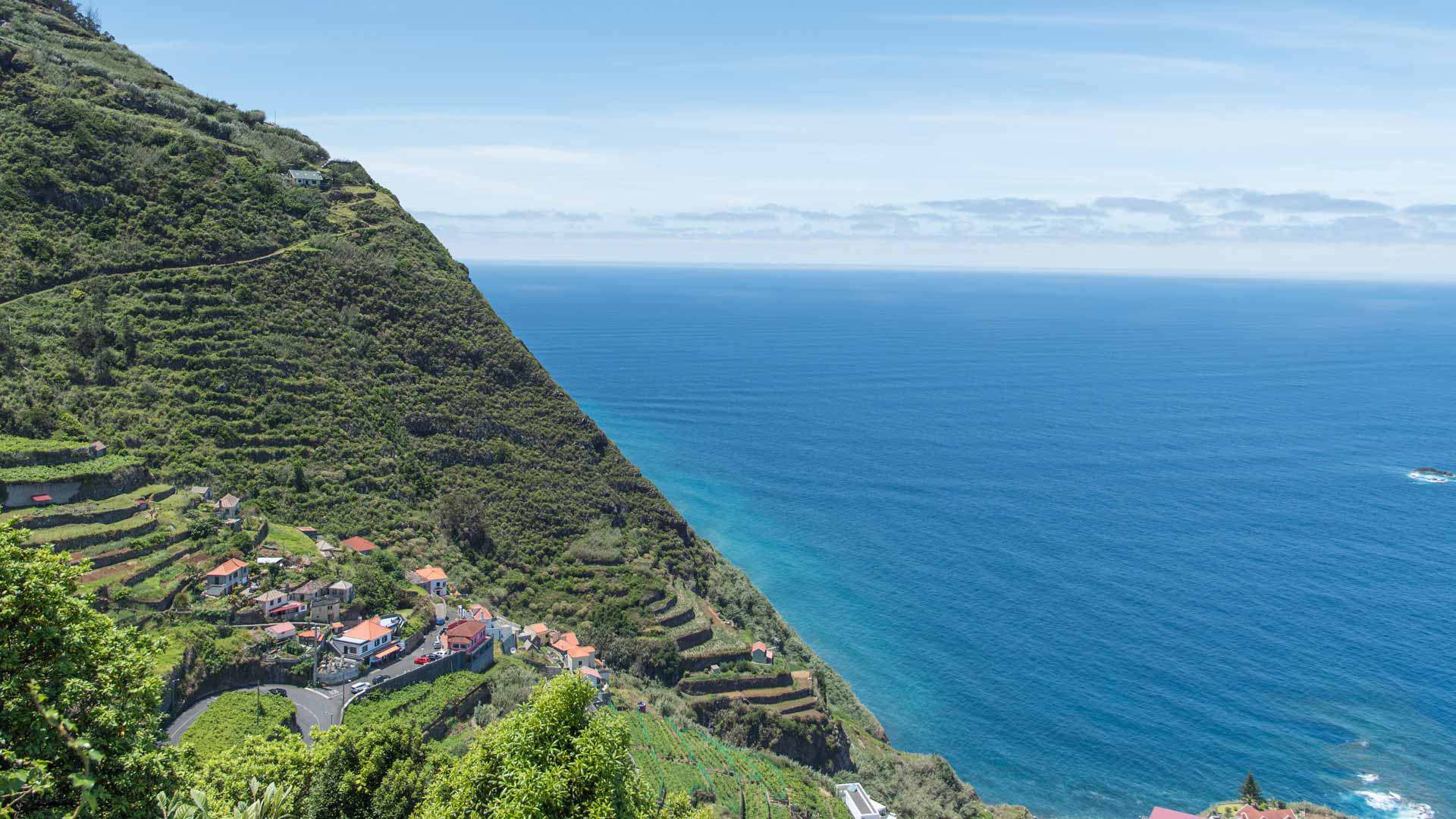 Maisons sur la pente verte avec vue sur la mer à Madère.